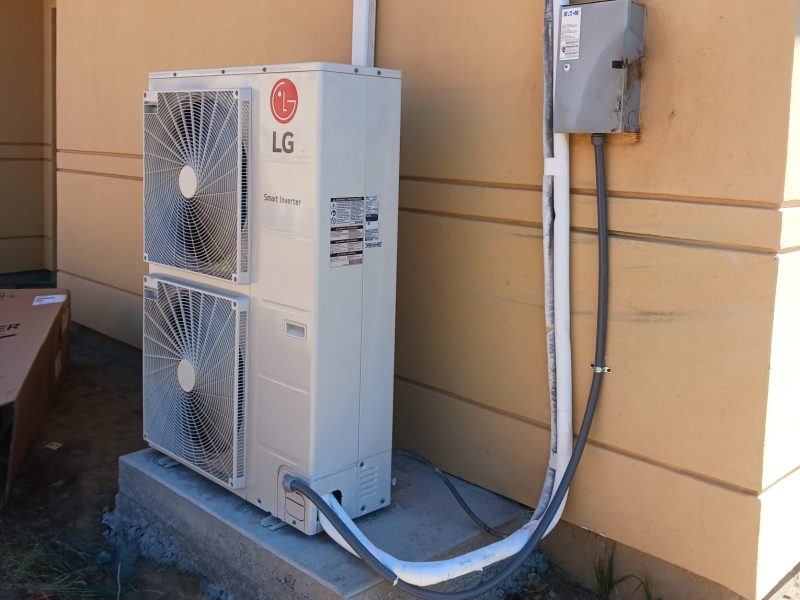New LG inverter heat pump on a concrete pad with disconnect box and insulated linesets